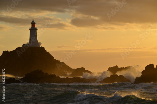 La Corbiere lighthouse, Jersey, U.K. Coastal structure at sunset.