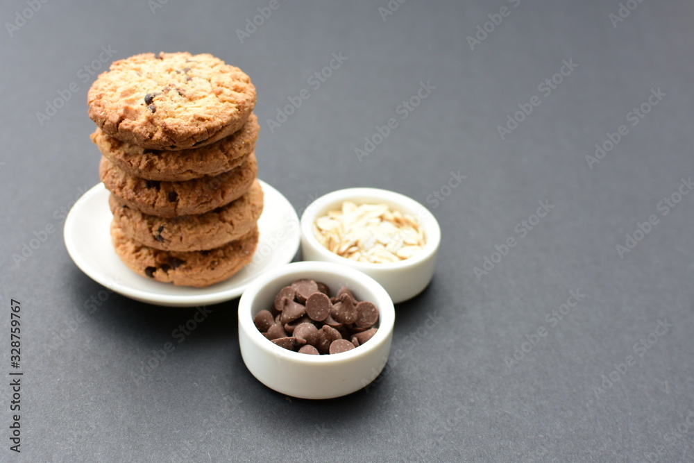 Oatmeal cookies and chocolate chips on black background Oatmeal cookies and chocolate chips on black background