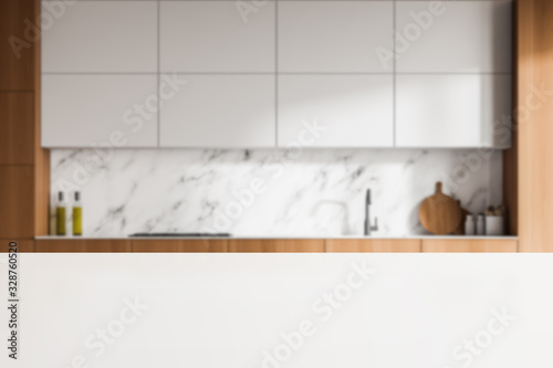 Table in blurry white marble kitchen