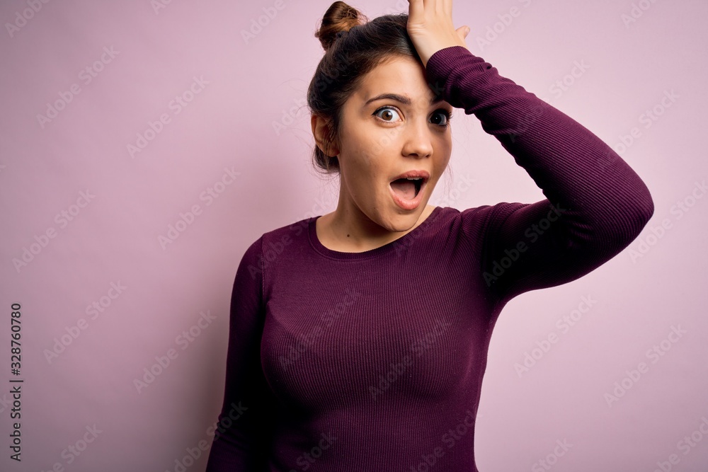 Beautiful young woman wearing casual bun hairstyle over pink isolated background surprised with hand on head for mistake, remember error. Forgot, bad memory concept. Beautiful young woman wearing casual bun hairstyle over pink isolated background surprised with hand on head for mistake, remember error. Forgot, bad memory concept.