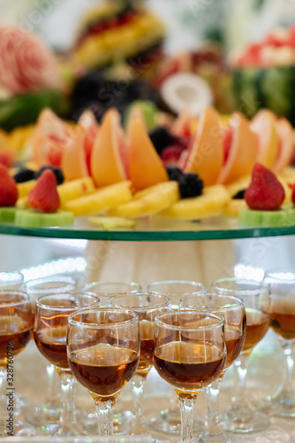 Alcoholic cocktail on festive table with watermelon, grape, banana and different fresh fruits. Celebration or other event