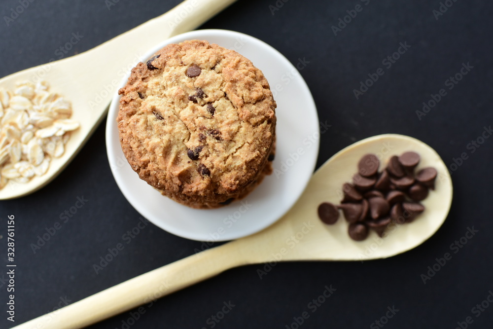 Oatmeal cookies and chocolate chips on black background Oatmeal cookies and chocolate chips on black background