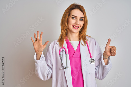 Redhead caucasian doctor woman wearing pink stethoscope over isolated background showing and pointing up with fingers number six while smiling confident and happy.