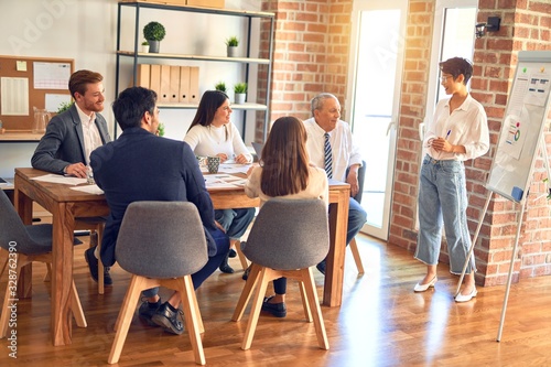 Group of business workers working together in a meeting. One of them making presentation to colleagues at the office © Krakenimages.com