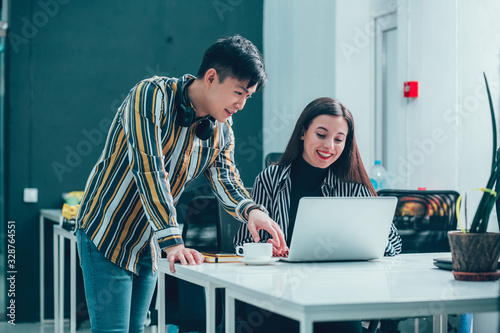 Εκτύπωση καμβά Friendly young man helping his coworker stock photo