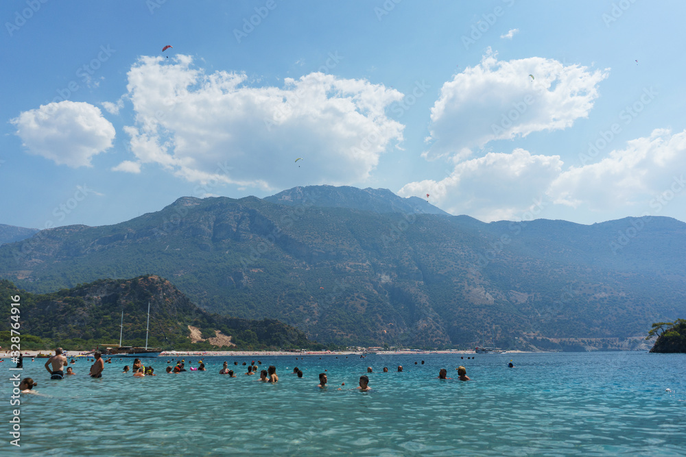 Vacationers and families children swim in lagoon. Sunbathing on sunbeds umbrellas. Editorial.