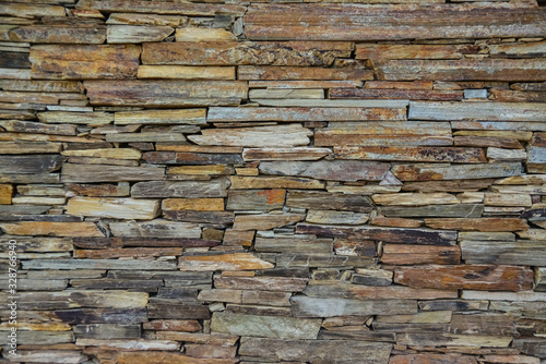 Stone wall made of multi-colored layered natural sandstone