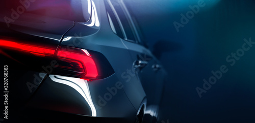 Back of the modern car on dark background with rear LED light close up (3D Illustration)