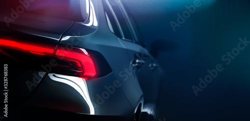 Slika na platnu Back of the modern car on dark background with rear LED light close up (3D Illus