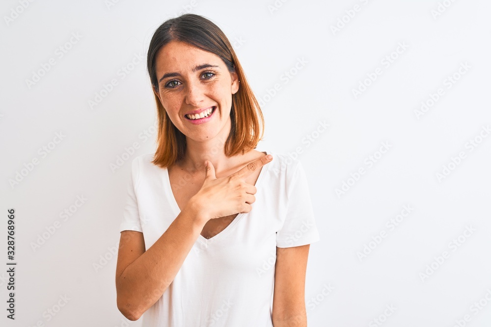 Beautiful redhead woman wearing casual white t-shirt over isolated background cheerful with a smile of face pointing with hand and finger up to the side with happy and natural expression on face Beautiful redhead woman wearing casual white t-shirt over isolated background cheerful with a smile of face pointing with hand and finger up to the side with happy and natural expression on face