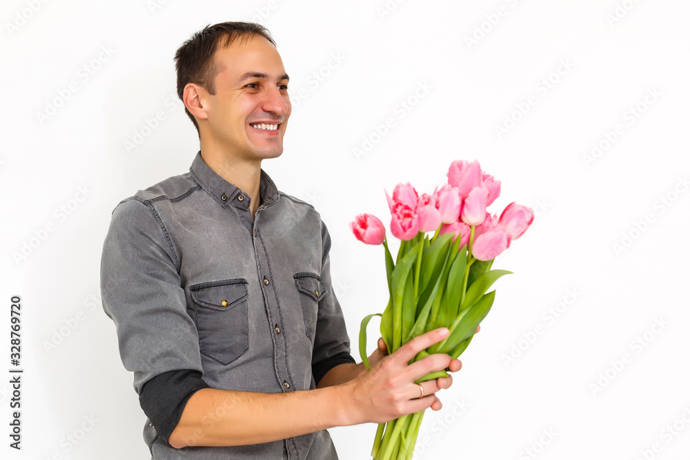 Man with flowers. Romantic Man with bouquet of tulips for birthday. Happy woman's day. Giving bouquet of flowers. Handsome man giving flowers. White background. Horizontal photo.s Man with flowers. Romantic Man with bouquet of tulips for birthday. Happy woman's day. Giving bouquet of flowers. Handsome man giving flowers. White background. Horizontal photo.s