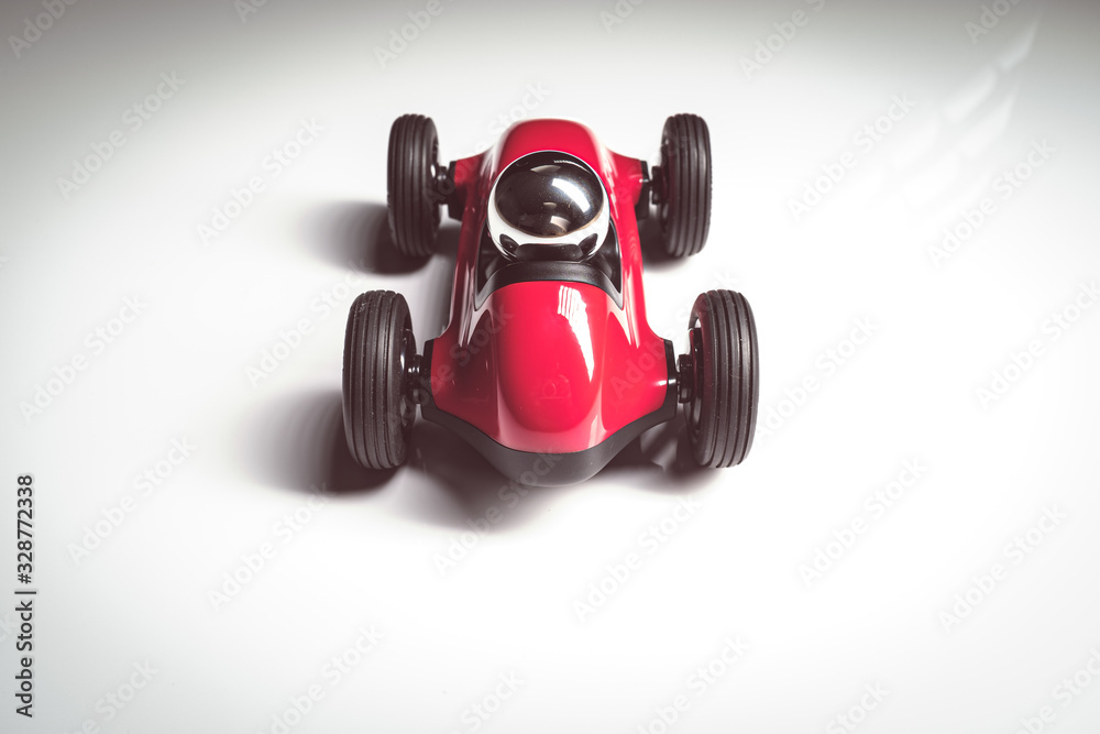 Red vintage racing tiny car backwards on a studio shot