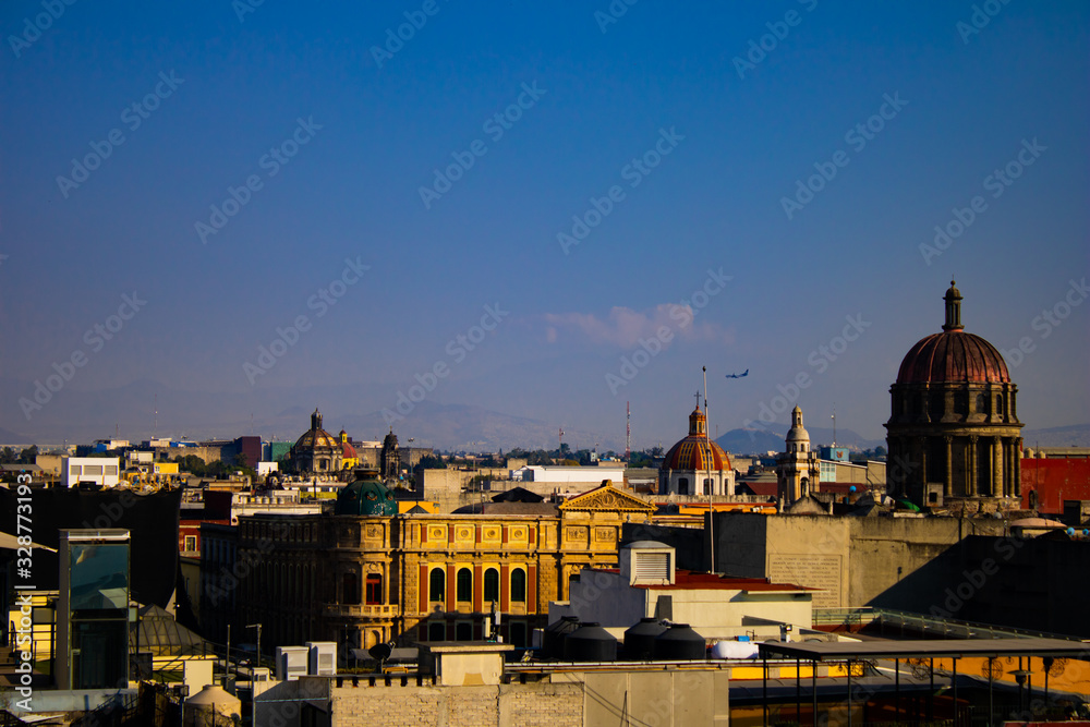 Fototapeta premium Beautiful landscape view of the historic centre of Mexico City, Mexico with an airplane at the horizon 