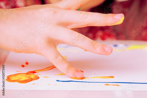 Child girl painting with colorful finger. Childhood, art, education concept.