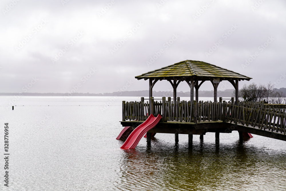 Maguide lake forest wood hut on wooden stilts on coast beach water in cloudy day Maguide lake forest wood hut on wooden stilts on coast beach water in cloudy day