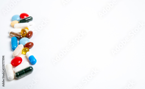many colored pills on the left side on a white background