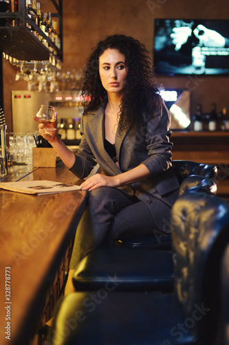 Elegant lady in a business suit, in a restaurant at a bar counter alone photo