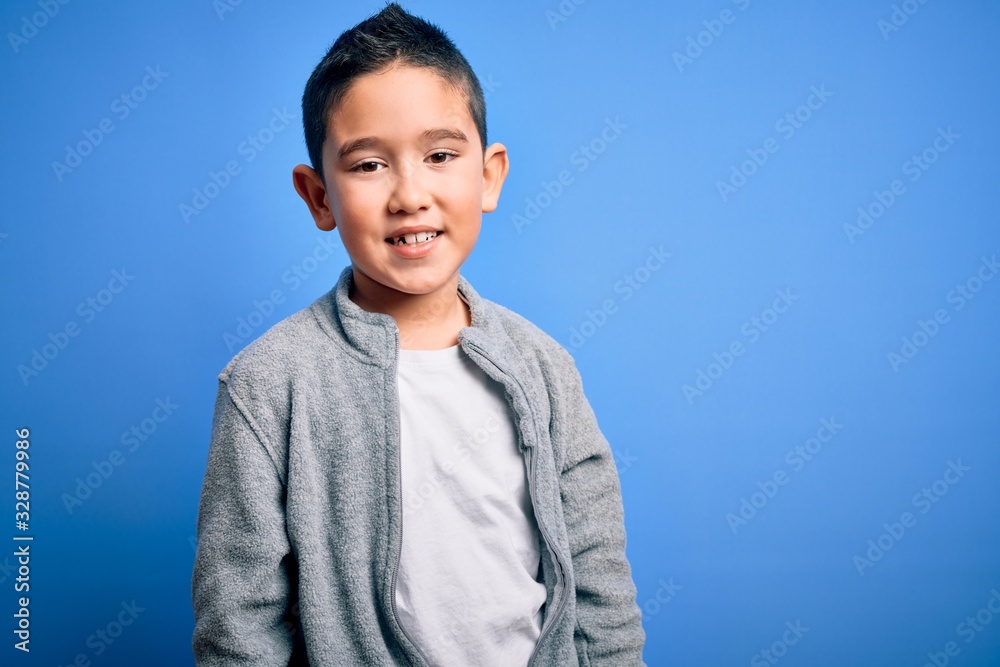 Young little boy kid wearing sport sweatshirt over blue isolated background with a happy and cool smile on face. Lucky person. Young little boy kid wearing sport sweatshirt over blue isolated background with a happy and cool smile on face. Lucky person.