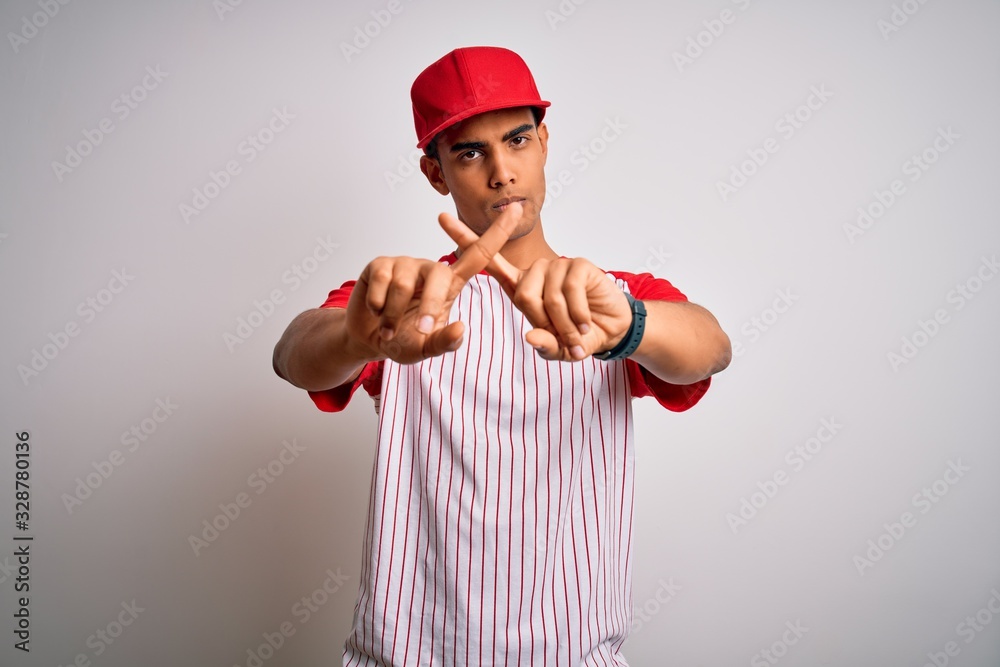 Young handsome african american sportsman wearing striped baseball t-shirt and cap Rejection expression crossing fingers doing negative sign