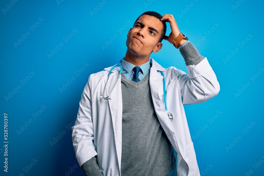 Handsome african american doctor man wearing coat and stethoscope over blue background confuse and wondering about question. Uncertain with doubt, thinking with hand on head. Pensive concept. Handsome african american doctor man wearing coat and stethoscope over blue background confuse and wondering about question. Uncertain with doubt, thinking with hand on head. Pensive concept.