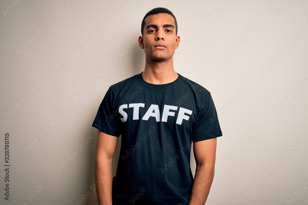 Young handsome african american worker man wearing staff uniform over white background Relaxed with serious expression on face. Simple and natural looking at the camera. Young handsome african american worker man wearing staff uniform over white background Relaxed with serious expression on face. Simple and natural looking at the camera.