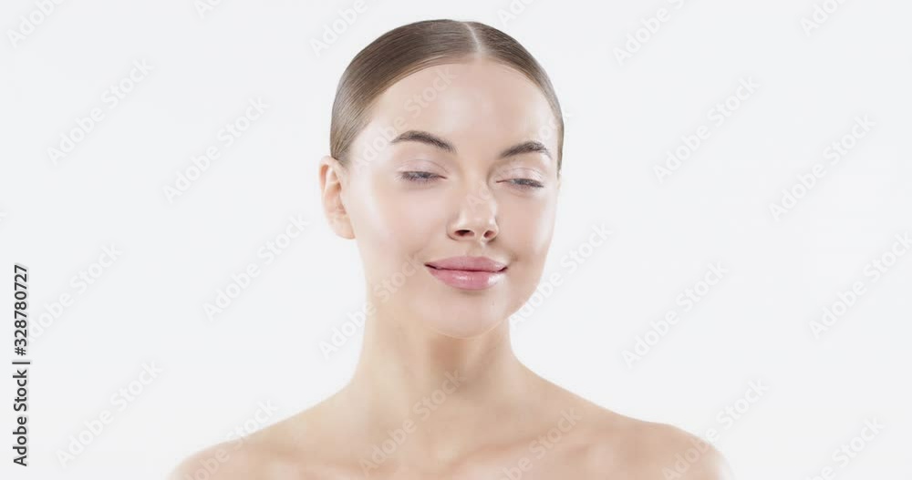 Beautiful young woman with blue eyes and perfect skin touching face with hands, isolated on white  background. Skincare and natural beauty concept