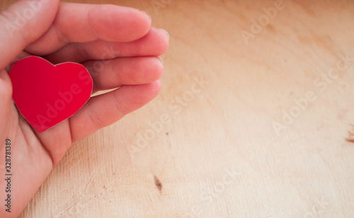hand holding a red heart, health insurance, organ donor day, charity, foster family concept