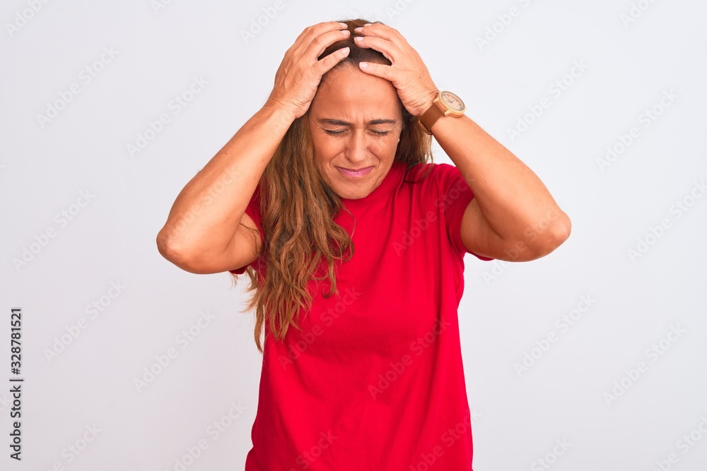 Middle age mature woman standing over white isolated background suffering from headache desperate and stressed because pain and migraine. Hands on head. Middle age mature woman standing over white isolated background suffering from headache desperate and stressed because pain and migraine. Hands on head.