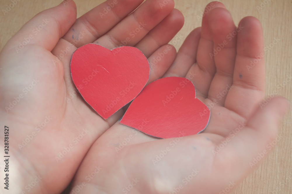 Obraz premium two red hearts in children's hands, healthcare, love, organ donation, family insurance and the concept of CSR, World Heart Day, World Health Day, fair trade