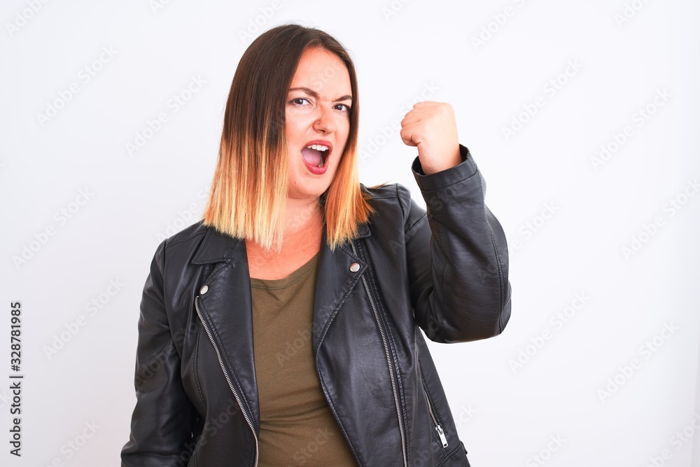 Young beautiful woman wearing t-shirt and jacket standing over isolated white background angry and mad raising fist frustrated and furious while shouting with anger. Rage and aggressive concept. Young beautiful woman wearing t-shirt and jacket standing over isolated white background angry and mad raising fist frustrated and furious while shouting with anger. Rage and aggressive concept.
