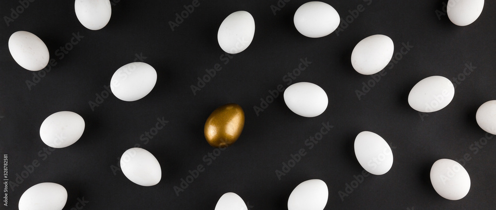 White and gols eggs arranged on black background