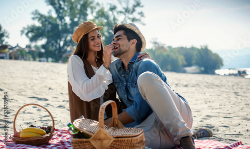 Picnic. Young couple having fun on the beach. Lifestyle, love, dating, vacation concept