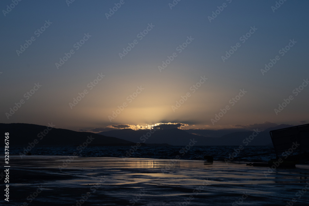 Sunset on aegina island in greece with clouds