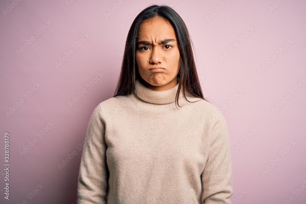 Young beautiful asian woman wearing casual turtleneck sweater over pink background skeptic and nervous, frowning upset because of problem. Negative person.