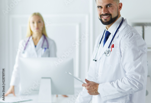 Happy medical team of doctors, man and woman, isolated over white background in a hospital room