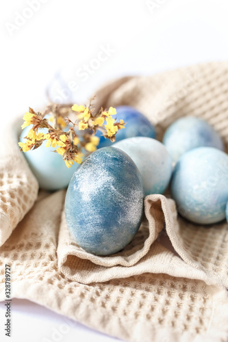 Easter atmosphere. Dyed Easter eggs and spring flowers on a white background. Easter atmosphere.