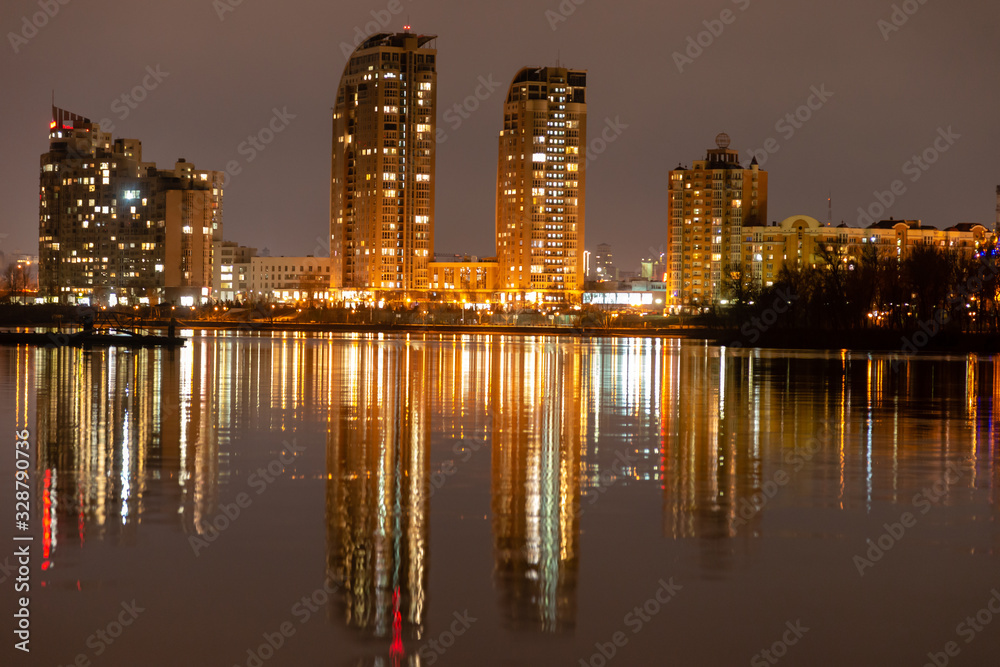 Kiev, obolon. The houses of the night city are reflected in the water.