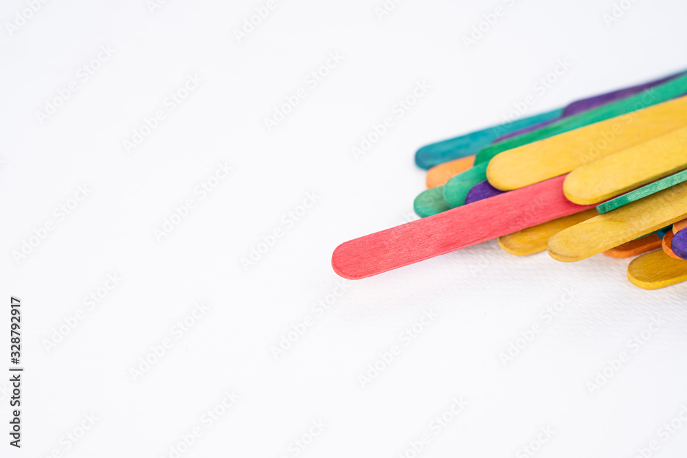 Red popsicle stand out from the group of colorful craft wooden sticks Red popsicle stand out from the group of colorful craft wooden sticks