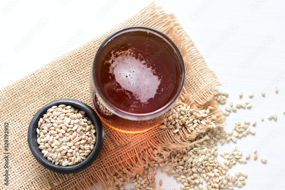 Raw barley grains, released in containers and accompanied by a glass of beer Raw barley grains, released in containers and accompanied by a glass of beer