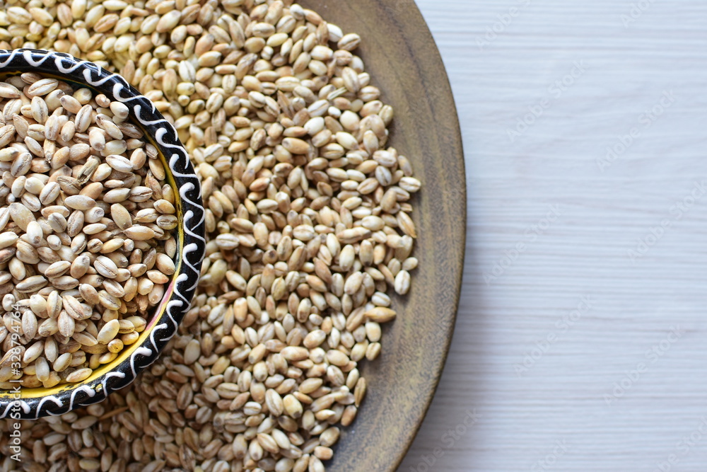 Obraz premium Raw barley grains, displayed in containers on rustic background