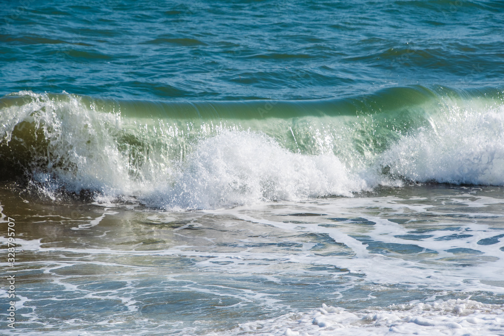 Mediterranean sea at sunset. Waves break on the sandy shore, sea foam. Natural background Mediterranean sea at sunset. Waves break on the sandy shore, sea foam. Natural background