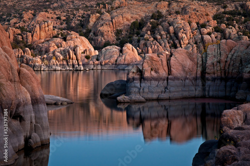 The granite rock formations of the Granite Dells area of Watson Lake glow in the twilight of a fading southwestern sunset. Prescott, Arizona.