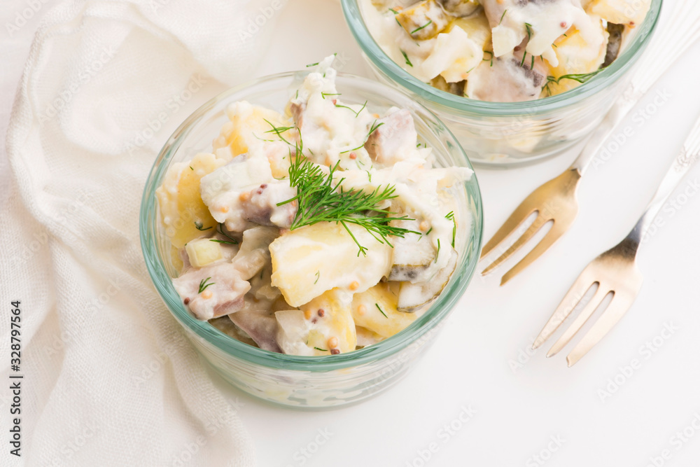 Salad rasols made of herring, cucumber and potato, dressed with mayonnaise and mustard Salad rasols made of herring, cucumber and potato, dressed with mayonnaise and mustard