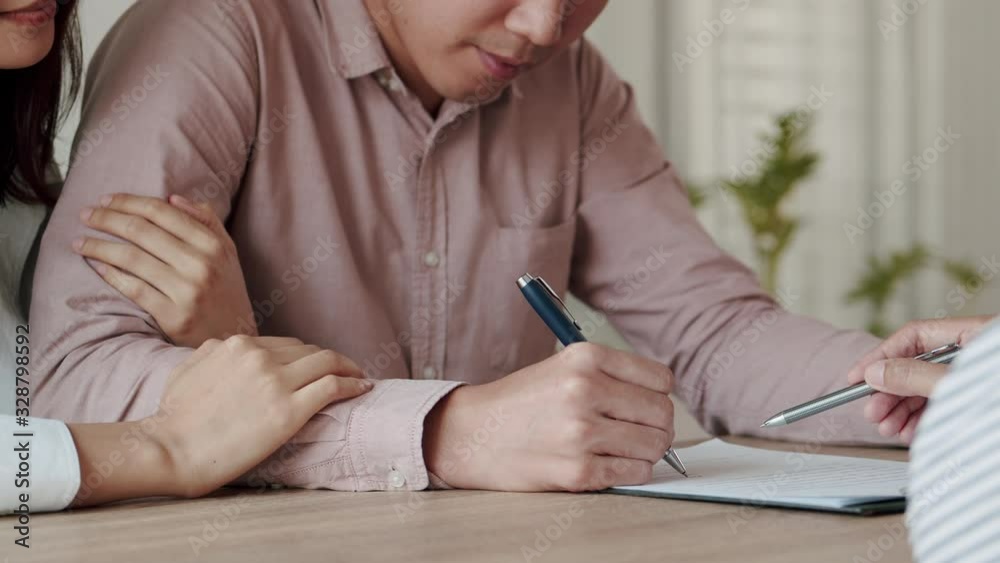Salesmen are letting the male customers sign the sales contract, Asian women and couple are doing handshake agreement business in the office. Business concept and contract signing