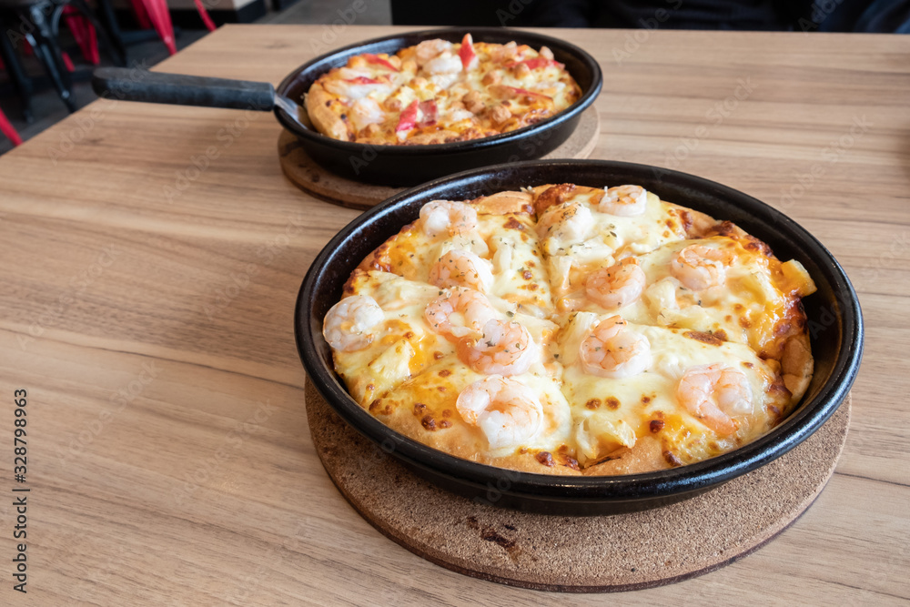 Set of delicious seafood pizza topped with cheese, pineapple, crab sticks and shrimp on wooden table. Pizza is a favorite food for many around the world. Set of delicious seafood pizza topped with cheese, pineapple, crab sticks and shrimp on wooden table. Pizza is a favorite food for many around the world.