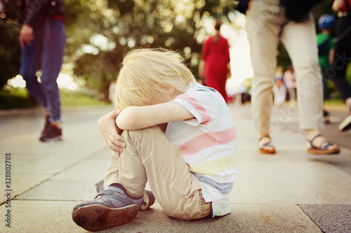 Toned shot of upset little child which was lost in street of city. Run away from home. Quarrel, divorce of parents.