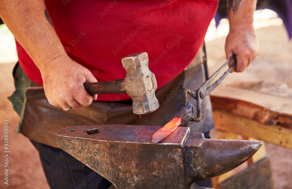Blacksmith making a knife blade on an anvil Blacksmith making a knife blade on an anvil