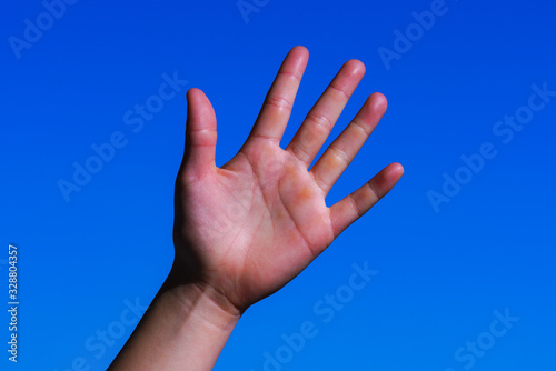 Japanese girl's palm in the background of blue sky