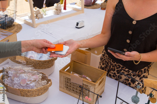 Woman paying for purchases with credit card at outdoor markets photo