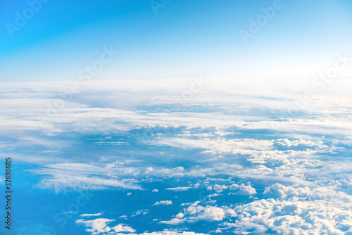 Aerial view of blue sky with layers of white fluffy cumulus and cirrus clouds